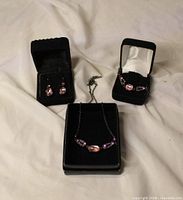 Necklace, bracelet and earrings with pink stones in display boxes