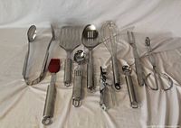 All ten stainless steel kitchen utensils laid out for overview