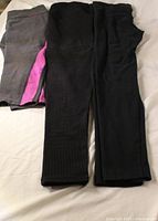 Three pairs of leggings laid flat showing colors and condition
