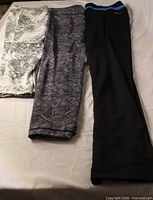 Three pairs of leggings laid flat showing colour and patterns