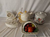 All four ceramic items arranged together: potpourri pot, tea-for-one set, trinket boxes, fruit basket