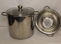 Stock pot with lid beside stainless colander