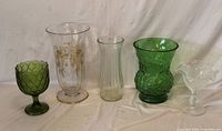 Five assorted glass items lined up on white backdrop