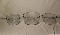 Three clear glass Anchor Hocking mixing bowls, two small and one large
