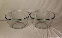 Two identical clear glass mixing bowls side by side, showing size, shape and condition