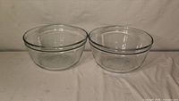 Two identical clear glass mixing bowls side by side
