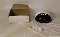 Lamp, USB cable and box displayed on surface