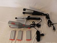 All hair styling tools and accessories laid out: Conair curling iron, Conair flat iron, Wave Rage crimper, four crimping plates, power cords visible