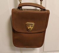 Front view showing purse shape, color, handle and crest