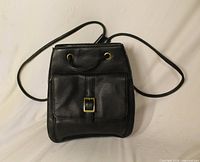 front view showing flap, front pocket, buckle and straps