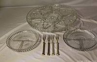 Large and small pressed glass divided plates with four metal appetizer forks