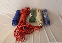Five coiled rope bundles in assorted colours and materials