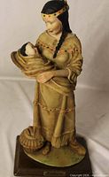 Full view of HOMCO figurine showing woman holding baby on wooden base