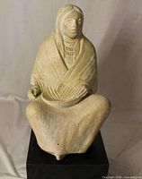 Front view of seated figure sculpture on base