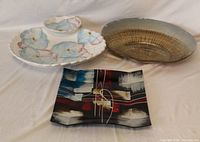 Three decorative platters: ceramic floral chip-and-dip with bowl, oval metallic-finish platter, rectangular fused glass platter