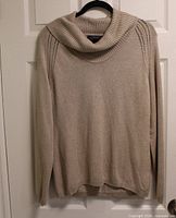 Front view of beige Liz Claiborne cowl-neck sweater on hanger