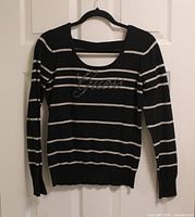 front view of Guess striped sweater on hanger