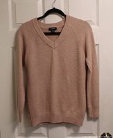 Front view of light pink Le Chateau V-neck sweater on hanger