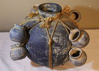 full view of blue spherical jug with rope and attached cups