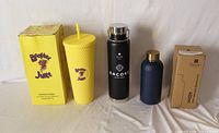 Yellow Booster Juice box, yellow tumbler, black Elite Encore bottle, navy bottle with box