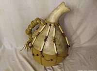 Front view of handcrafted water jug showing shape, handle, and bead decoration