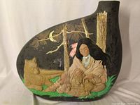 Full view of black ceramic jug with Native American relief scene