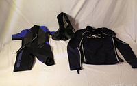All three items laid out: wetsuit, rash guard, booties