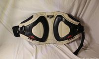 Front view of Prolimit beige and black waist harness showing padding, logos, buckles and hook