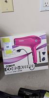 Box front showing model name, wattage and image of pink hair dryer