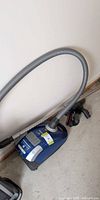 Blue Miele Momentum canister vacuum with hose and wand