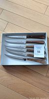 Set of six serrated knives in tray