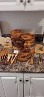 Entire assortment of wooden bowls, utensils, trivets, coasters and board on counter