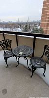 Wrought iron bistro set with round table and two chairs on balcony