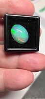 Front view of oval jelly opal in black gem box
