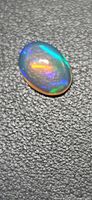 Top view of oval opal showing blue and orange flashes