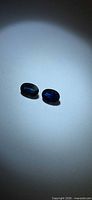 Pair of oval blue sapphires on neutral background