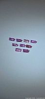 Eight pink sapphire baguettes arranged on neutral background