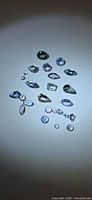 All 22 loose Tanzanite stones laid out, showing varied cuts and colors