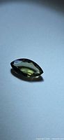 Top view of marquise green sapphire on neutral background