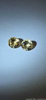 Two round yellow helidor gemstones side by side under direct light
