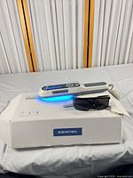 Device emitting blue light resting on box with safety glasses
