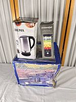 All three boxed appliances stacked: Aroma kettle, BlendJet blender, chafing dish set