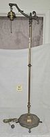 Full view of floor lamp showing swing arm, socket, pole, base and cord