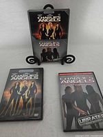 Front view of three DVD cases including sealed double-feature and two individual titles