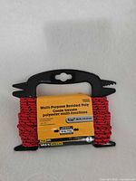 Front view of packaged red braided polypropylene cord on black spool
