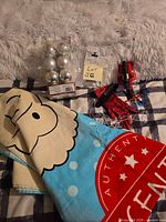 Overview of towel, silver ornaments pack, plastic bag label, Spiderman glove and launcher pieces