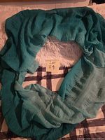 Full view showing teal infinity scarf laid flat