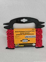 Front view showing red braided cord, label with specifications, and black plastic winder