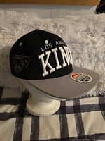 Left profile of hat on stand showing front and side logos