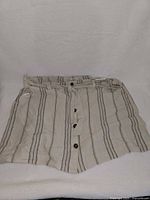 Front view of striped shorts showing buttons and belt